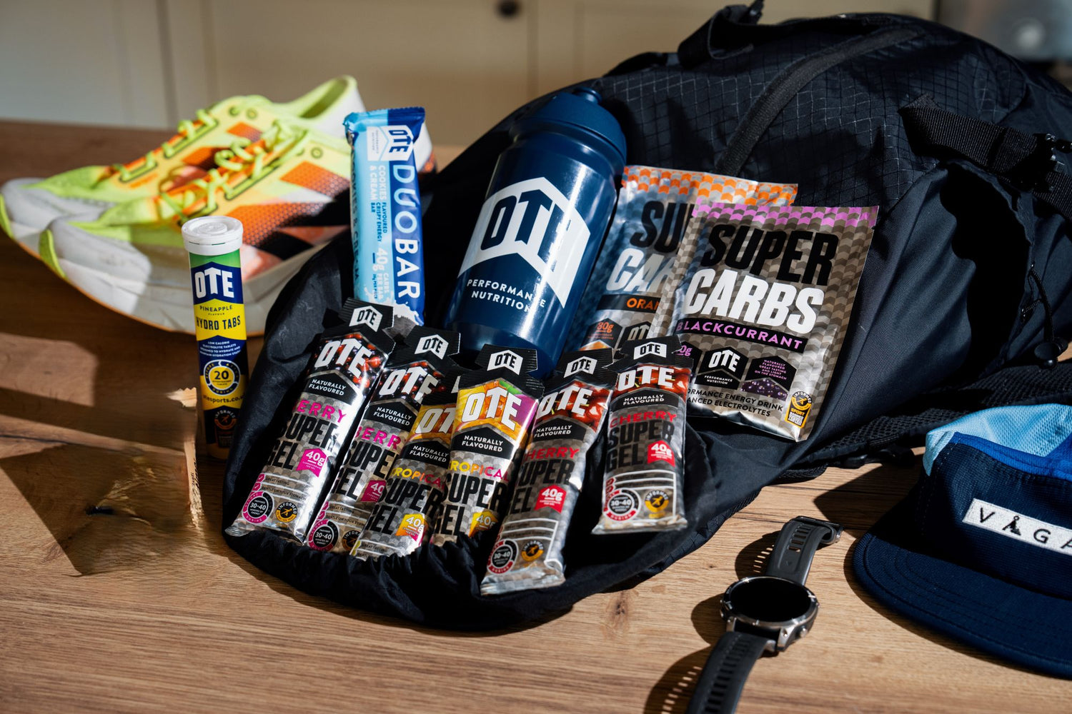 Supplement products including protein bars and drinks on a wooden surface with a black bag.