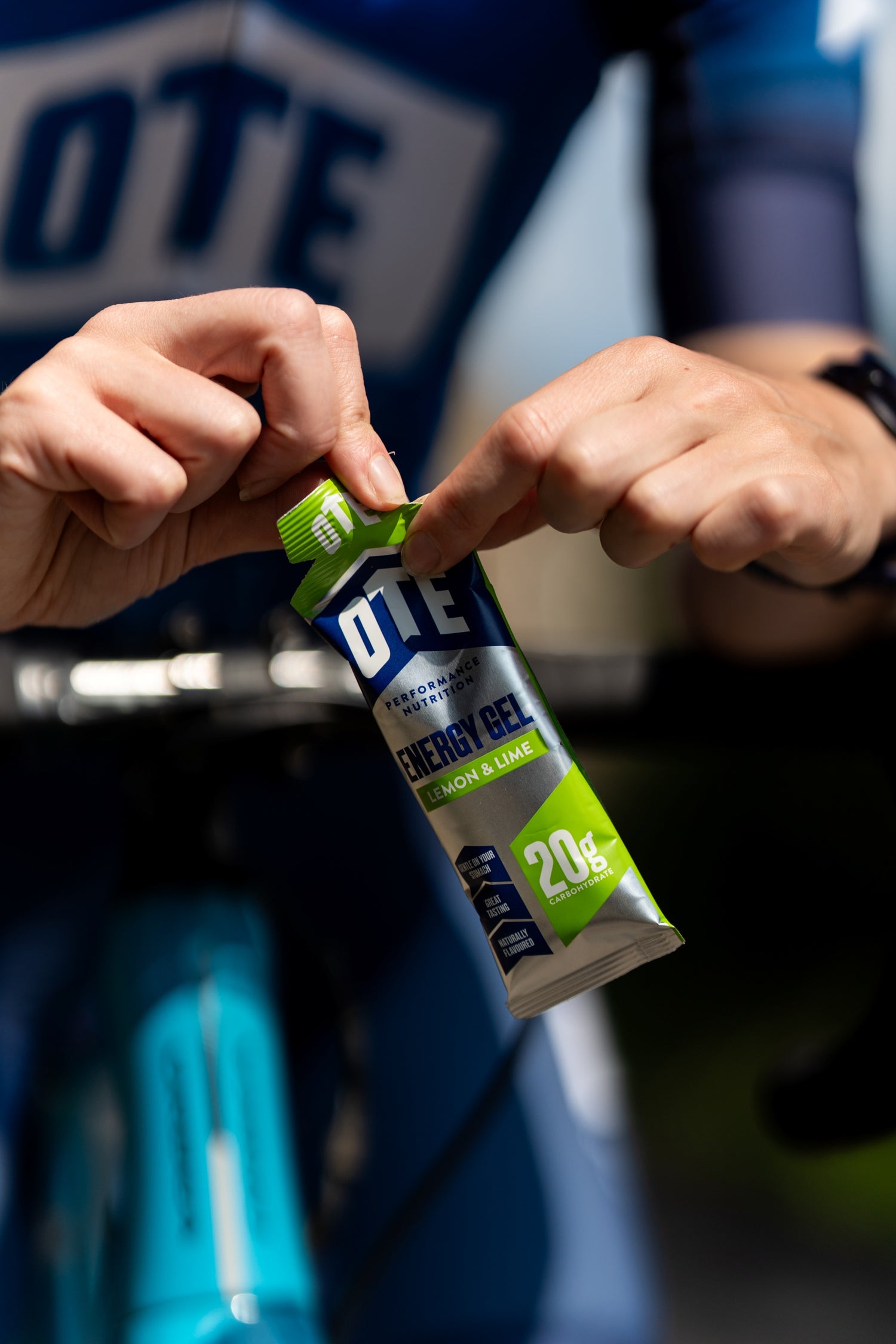 Person holding a DTE energy gel package with a blurred background