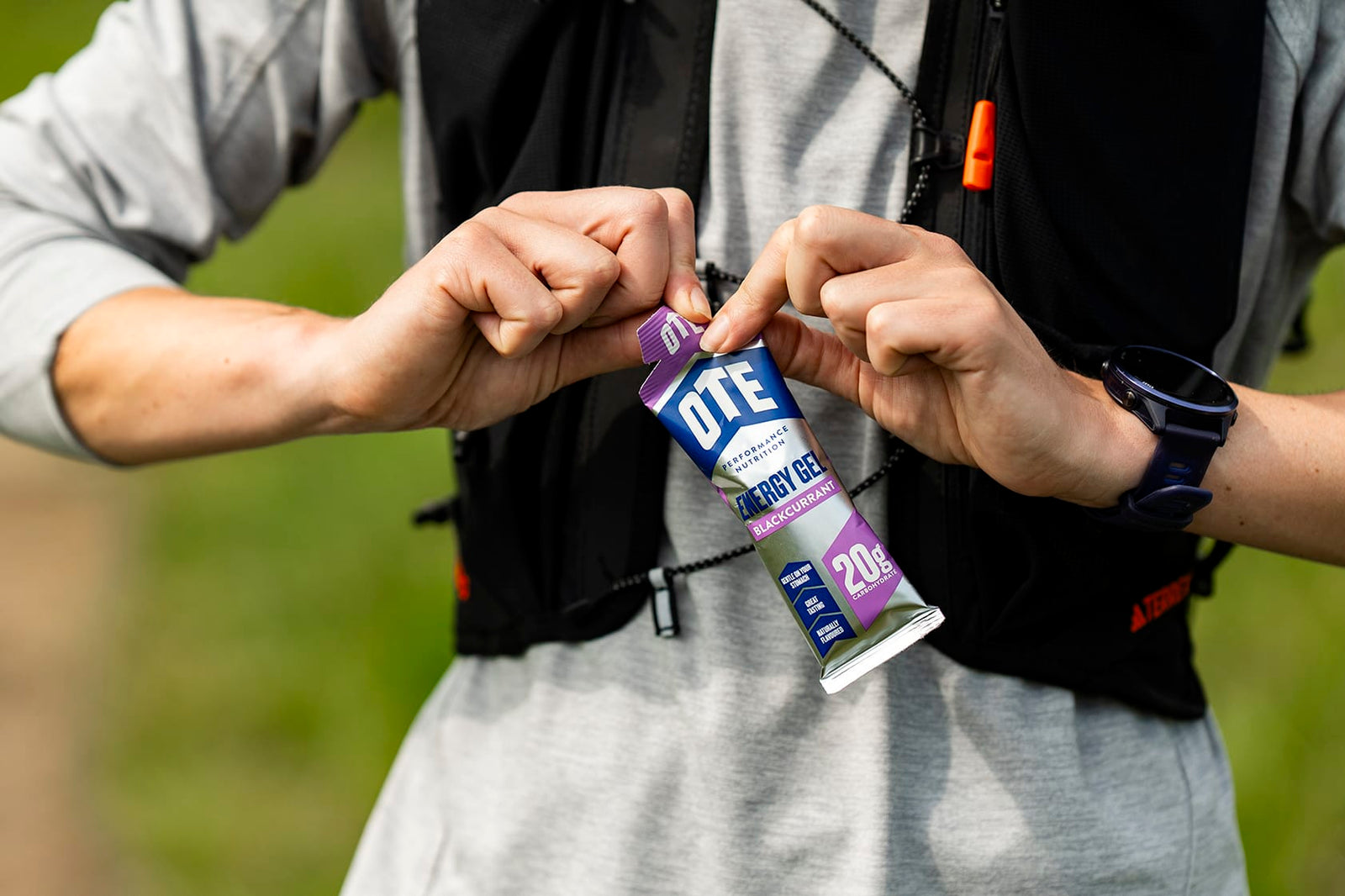 Two people holding a OTE sports drink mix outdoors.