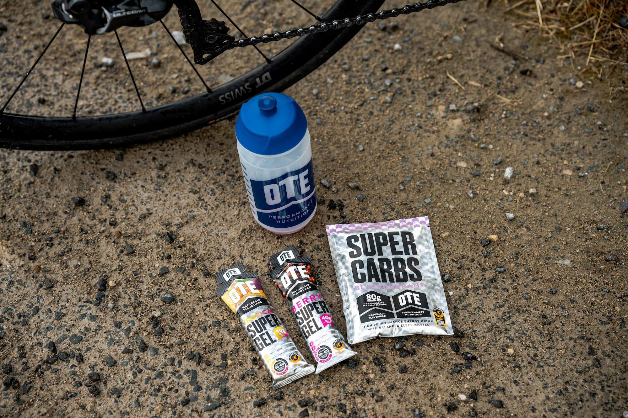 OTE Sports energy gels and drink sachet placed next to a bike.